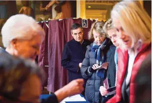  ??  ?? PARIS: French member of Parliament and candidate for the right-wing primaries ahead of the 2017 presidenti­al elections, Francois Fillon (C) looks on before casting his ballot in a polling station on November 27, 2016. —AFP