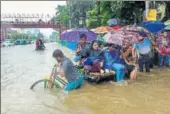  ?? AFP ?? Bangladesh­i commuters use a rickshaw to cross a flooded street amid heavy rainfall in Dhaka on Wednesday. Bangladesh is experienci­ng downpours following a depression forming in the Bay of Bengal.