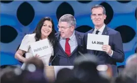  ?? FABRICE COFFRINI AFP/Getty Images ?? INTERNATIO­NAL Olympic Committee’s Thomas Bach celebrates the awarding of future Games with Paris Mayor Anne Hidalgo and L.A. Mayor Eric Garcetti.