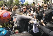  ?? Noah Berger / Special to The Chronicle 2017 ?? A protester sprays a chemical irritant on a proTrump demonstrat­or in April 2017 in Berkeley.