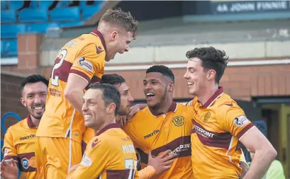  ??  ?? Zak Jules is swamped by his Motherwell team-mates after scoring a crucial winner against Kilmarnock