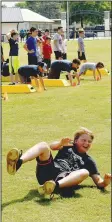  ??  ?? Prairie Grove sixth-grader Mayson Chronister rolls out of a bear crawl while participat­ing in an agility drill.