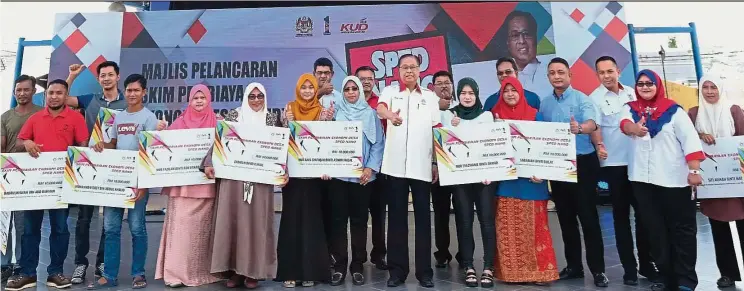  ??  ?? A lending hand: Ismail Sabri (11th from left) with the 15 loan recipients at the launch of SPED. — Bernama