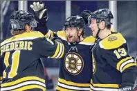  ?? Michael Dwyer / Associated Press ?? The Boston Bruins' Craig Smith, center, celebrates his goal with teammates Trent Frederic (11) and Charlie Coyle (13) during the second period against the Philadelph­ia Flyers on Saturday night.