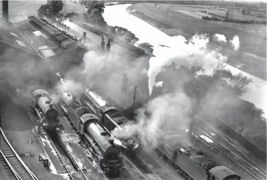  ?? D Dunn Collection ?? A picture from the Canal shed coaling tower in 1955 shows the close proximity of the river Eden. In the shed yard are a Gresley ‘J39’, Thomson ‘B1’, Reid ‘J35’ and Gresley ‘A3’, as well as Reid ‘C15’ 4-4-2T No 67458. The latter was completed in June 1912 by the Yorkshire Engine Co (Works No 1071) as NBR No 131, and it was Canal-allocated from March 1945. The Atlantic tank would be withdrawn on 16 March 1956, moving to Kilmarnock Works for dismantlin­g. Of interest are the pits outside the roundhouse, complete with a portable wooden workbench temporaril­y abandoned by a fitter, and the ‘J39’ is being oiled up, while to the right, judging by the ferocity of steam escaping from its safety valves, another locomotive is raring to depart. It is outside the three-road shed that started life as a wagon shop, its roofline differing from that of the roundhouse. After the mid-1930s re-evaluation of facilities at Canal and London Road, the option to adopt the wagon shop at Canal for locomotive use in effect saw six locomotive roads access the buildings on their east side, with these complement­ed by two dead-end roads outside the building and other lines south of the coaling plant.