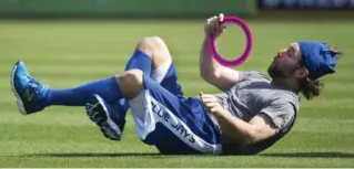  ?? NATHAN DENETTE/THE CANADIAN PRESS ?? Blue Jays knucklebal­ler R.A. Dickey makes an acrobatic catch while playing Frisbee Saturday in Dunedin, Fla. Pitchers and catchers get down to business starting Monday.