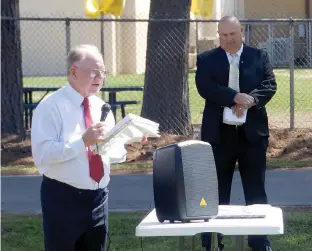  ??  ?? n Jimmy May, member of the James Bowie Alumni Associatio­n Board, addresses the attendees at the dedication ceremony of the new alumni center while Simms Independen­t School District Superinten­dent Rex Burks looks on Saturday in Simms, Texas.