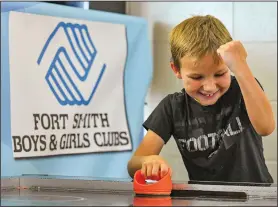  ?? (River Valley Democrat-Gazette/Hank Layton) ?? Grayson Burt, 8, reacts Thursday while playing air hockey at the Evans Boys & Girls Club.