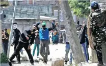  ?? Picture:AP ?? VIOLENCE: Kashmiri protesters throw stones at Indian security men outside a polling station during a by-election for an Indian Parliament seat in Srinagar, Indian-controlled Kashmir.