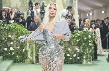  ?? GETTY ?? Kim Kardashian may have had a Galliano dress at the Met Gala, but she kept the chill off with a cosy cardy