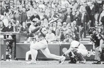  ?? ROBERT GAUTHIER LOS ANGELES TIMES ?? Los Angeles Dodgers’ Yasiel Puig hits a three-run home run in the sixth inning against the Brewers during Game 7 of the National League Championsh­ip Series at Miller Park in Milwaukee on Saturday night.