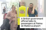  ??  ?? A British government official talks to passengers at Palma de Mallorca airport