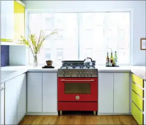  ??  ?? Colorful, eye-catching appliances, such as this tomato-red stove, will heat up the kitchen in style.