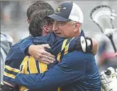  ?? Pete Bannan for the Post-Gazette ?? Coach Bob Marcoux hugs Aidan Moffa after Mars won the PIAA Class 2A championsh­ip.