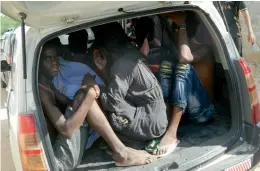  ??  ?? Students of the Garissa University College take shelter in a vehicle after fleeing from an attack by Al Shebab gunmen from Somalia while Kenyan police officers take positions outside the university as an ambulance carrying the injured leaves for a...