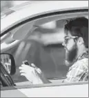  ?? LM OTERO / ASSOCIATED PRESS ?? A motorist uses his smartphone while driving in Dallas last week. Texas lawmakers are considerin­g banning texting while driving.