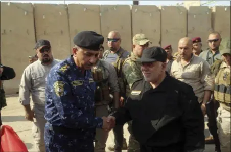  ?? IRAQI FEDERAL POLICE PRESS OFFICE VIA AP ?? Iraq’s Prime Minister Haider al-Abadi, center right, shakes hands with Lieutenant General Raid Shaker Jawlat, center left, the commander of Iraqi federal police upon his arrival in Mosul, Iraq, Sunday. Backed by the U.S.-led coalition, Iraq launched...