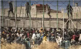  ?? Photograph: Javier Bernardo/AP ?? Riot police and migrants at the border between Morocco and the Spanish enclave of Melilla, June 2022.