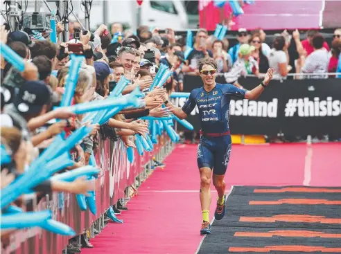  ?? Picture: BRENDAN RADKE ?? YOU BEAUTY: 2017 Ironman Cairns men's winner Josh Amberger crosses the finish line on the Cairns Esplanade.