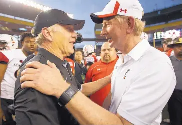  ?? AP FILE ?? San Diego State head coach Rocky Long, left, is congratula­ted by Cincinnati’s Tommy Tuberville after the Aztecs’ win in the Hawaii Bowl on Dec. 24.