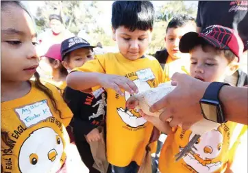  ?? ALEX HORVATH / THE VOICE ?? Students from Eissler Elementary School pet a chicken at one of 100 stations set up at Highland High School’s Fall Harvest Fest, where local elementary schools came by to learn about farming from FFA students on Nov. 8.