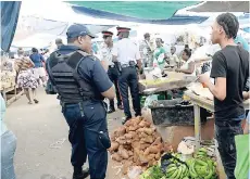  ??  ?? Police were on patrol at the Coronation Market in Kingston yesterday.