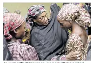  ?? / NIGERIA STATE HOUSE VIA AP SUNDAY AGHAEZE ?? An unidentifi­ed Nigerian government official (center) welcomes some of the 21 freed Chibok schoolgirl­s at the State House in Abuja, Nigeria, on Thursday.