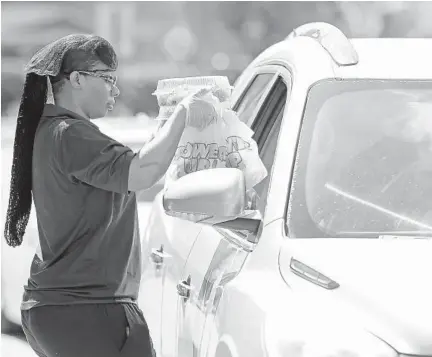  ?? SUN SENTINEL 2020 AMY BETH BENNETT/SOUTH FLORIDA ?? Katrina Bell delivers grab-and-go meals to people in the car loop at Dillard High School in Fort Lauderdale on March 16.