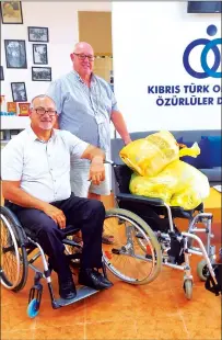  ?? Photo courtesy of the ATA ?? Philip Lloyd presenting the wheelchair to Gunay Kibrit at the KTOÖD offices