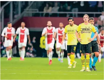  ?? FOTO: PETER DEJONG/AP ?? Fassungslo­s nach dem Hinspiel: Die Dortmunder Emre Can (2.v.r.) und Julian Brandt (r.) lassen nach dem Abpfiff in Amsterdam alles noch einmal Revue passieren.