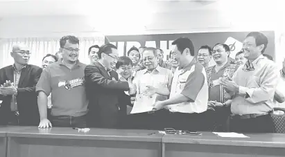  ??  ?? MANAH: Chong (dua kanan) nerima ‘DAP Dayak Blueprint’ ari Paul seraya dikemataka Lim (tengah) enggau orang bukai.