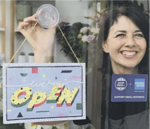  ?? PICTURE: PA ?? 0 Michelle Macarthur, from Moss Flowers in Glasgow, displays a sign designed by artist Yukai Du, which has been created to help Scottish retailers welcome people back to the high street.