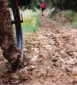  ??  ?? Photo shows clay sticking to a bike tire after a rainstorm on the Maah Daah Hey Trail near Medora, North Dakota as Ryan Johnson is returning to his riding group to give a trail-conditions update.