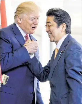  ??  ?? SHOW OF HANDS: President Trump greets Japanese Prime Minister Shinzo Abe with a “bro” handshake outside the White House’s West Wing on Friday.