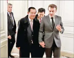  ?? SPM ?? Former Prime Minister Hun Sen (centre left) and President Emmanuel Macron of France hold hands in Paris on December 13, 2022.