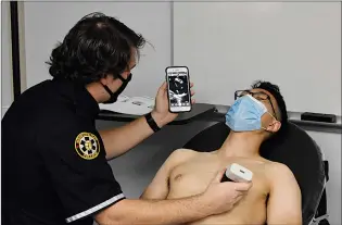  ?? SUBMITTED PHOTO ?? An MHC paramedic student uses handheld ultrasound technology to look inside a volunteer.