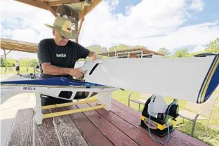  ?? PHOTOS BY RICARDO RAMIREZ BUXEDA/STAFF PHOTOGRAPH­ER ?? Larry Meddock works on one of his remote-controlled planes at the Remote Control Associatio­n of Central Florida’s Tangerine Field in Apopka on Friday. Below, a model plane takes flight at Tangerine Field.