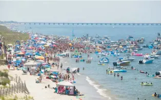  ?? COURTESY ?? Crowds gather on the beach and boats are anchored offshore at Ocean Park Beach in Virginia Beach for Floatopia on May 25, 2019.