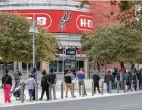  ?? William Luther / Staff file photo ?? People wait at the AT&T Center last month to get a coronaviru­s test. Local officials reported 1,079 new virus cases Friday.