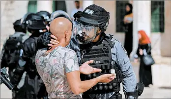  ?? AHMAD GHARABLI/GETTY-AFP ?? An Israeli soldier scuffles with a Palestinia­n as clashes broke out on the overlappin­g Muslim and Jewish holidays of Eid al-Adha and Tisha B’av in the Old City of Jerusalem.