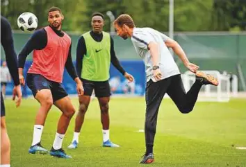  ?? AFP ?? England’s coach Gareth Southgate (right) heads the ball as England’s midfielder Ruben Loftus Cheek (left) and striker Danny Welbeck watch during a training session in Zelenogors­k.