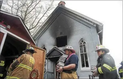  ?? RICK KAUFFMAN — DIGITAL FIRST MEDIA ?? Firefighte­rs carried out stacks of hymnals from the Memorial Presbyteri­an Church in Upper Chichester on Monday after a fire devastated the building.