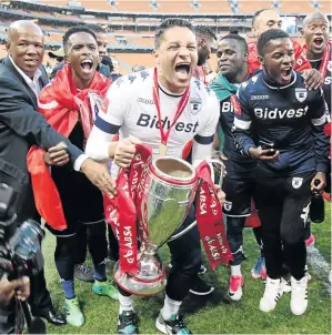  ?? / ANTONIO MUCHAVE ?? Moeneeb Josephs leads Bidvest Wits’ trophy celebratio­ns after they were officially crowned at FNB Stadium after their loss to Kaizer Chiefs.