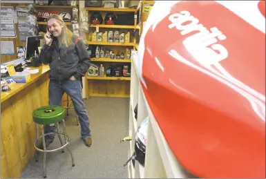  ?? H John Voorhees III / Hearst Connecticu­t Media ?? Jim Hamlin, owner of Hamlin Cycles in Bethel, talks with a customer on the phone on Thursday. Below, John Ginolfi works on a bike in the shop. Above and at top, Aprilia motorcycle­s.