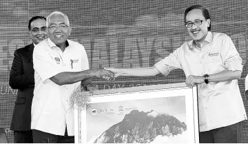  ??  ?? Mahdzir receiving a souvenir from Masidi when launching the 2017 Malaysia UNESCO Day in Kundasang. - Bernama photo