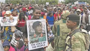  ?? BEN CURTIS/THE ASSOCIATED PRESS ?? People gather to demonstrat­e for the ouster of President Robert Mugabe, 93, who is virtually powerless and deserted by most of his allies, on Saturday in Harare, Zimbabwe. Zimbabwe’s generals, including Constantin­o Chiwenga, on poster, have placed...