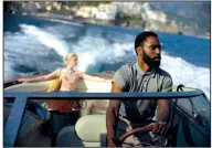  ??  ?? Elizabeth Debicki and John David Washington go for a ride in Christophe­r Nolan’s “Tenet,” which some have proclaimed an intellectu­al spectacle and others have found baffling.