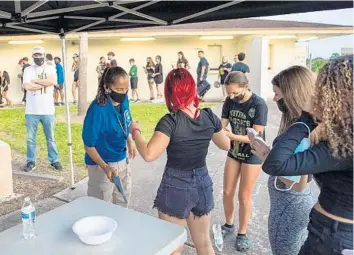  ?? MICHAEL LAUGHLIN/SUN SENTINEL ?? Entrants into Western High School are checked before the Wildcats’ game against Coconut Creek on Friday night. Heightened security measures began at Broward County high school football games this week following a shooting last week near Fort Lauderdale High School after a game.