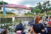  ?? SAKCHAI LALIT / ASSOCIATED PRESS ?? Buddhists pray with relatives of the victims of a mass killing in the rural town of Uthai Sawan, northeaste­rn Thailand, Sunday.