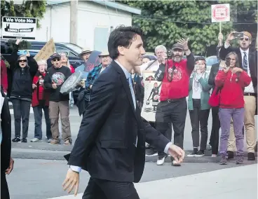  ?? — THE CANADIAN PRESS ?? Protesters opposed to the Kinder Morgan Trans Mountain pipeline expansion shout at Prime Minister Justin Trudeau as he arrives for talks on Tuesday.